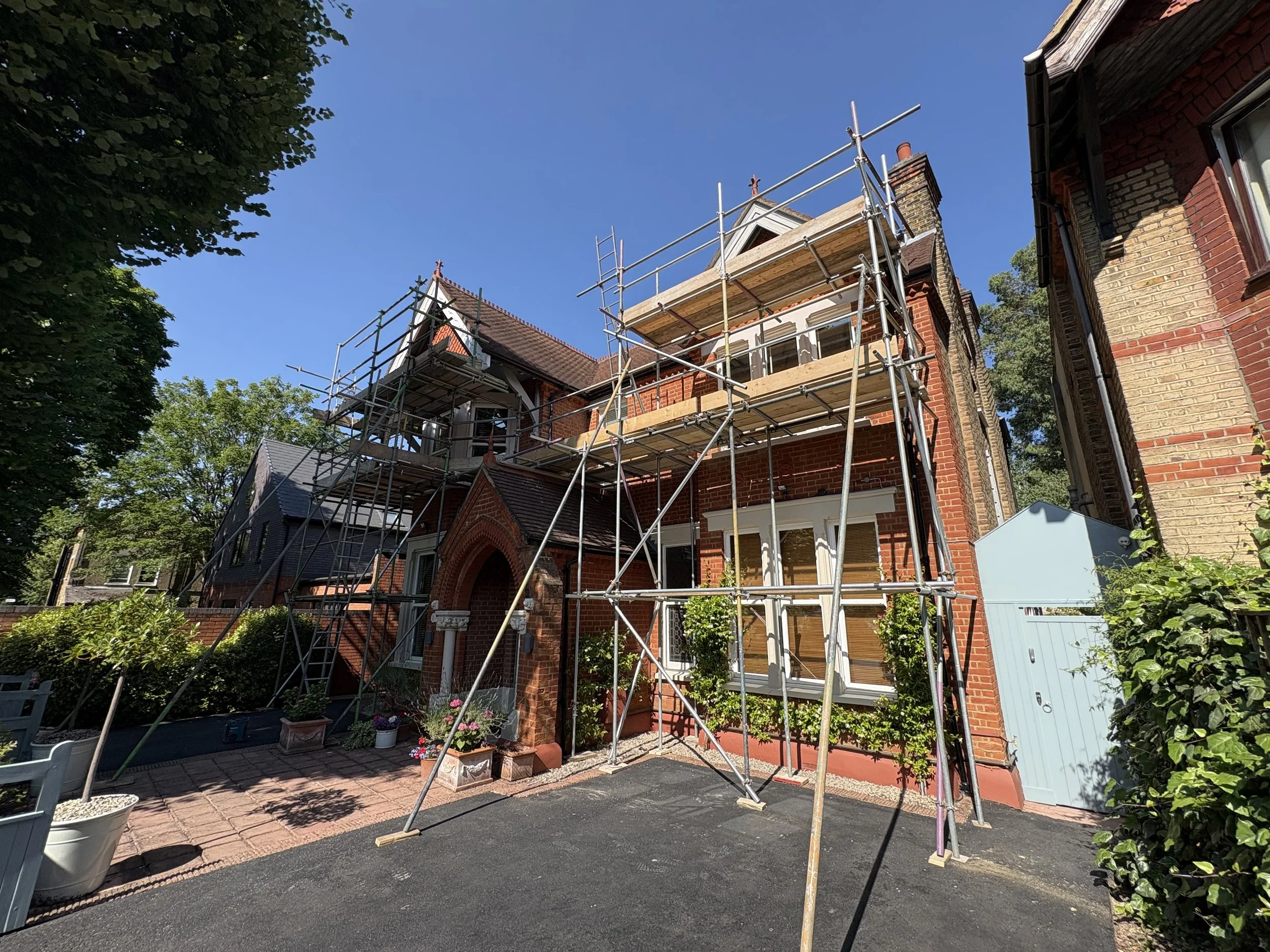 Multi-tier scaffold erected around a large Victorian Gothic red-brick house for restoration works