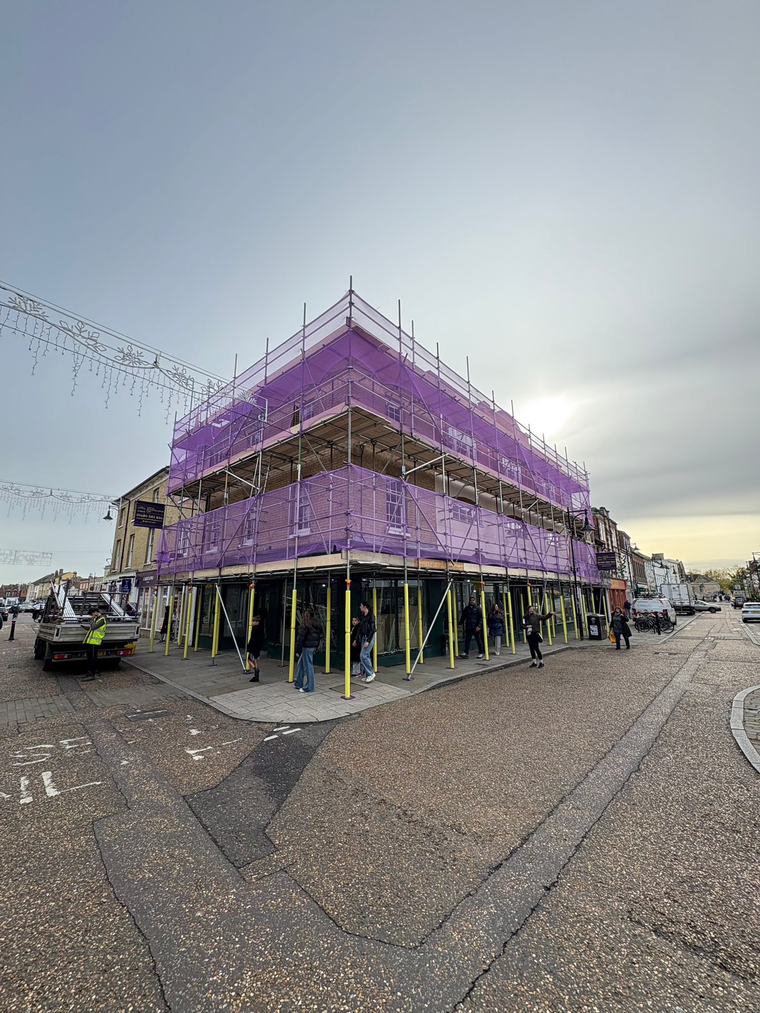 Local Scaffolding Ltd commercial scaffold wrapping a town-centre period property with purple debris netting
